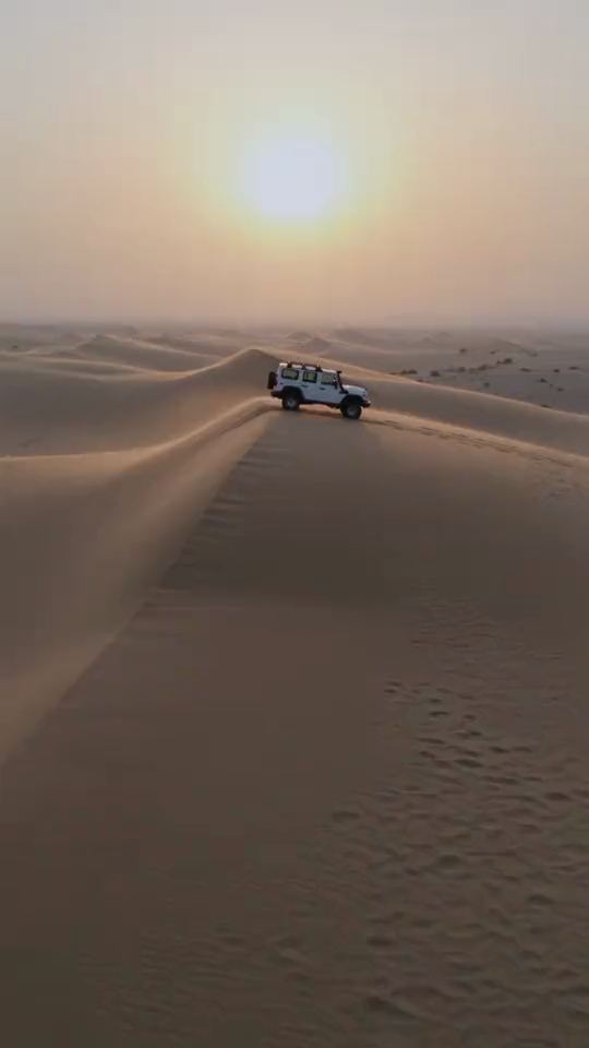 Drone push-in: White 4x4 on a dune